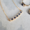 Rosecliff Bar necklace with eleven alternating 2mm round cut diamonds and sapphires, prong set in yellow gold - angled view.