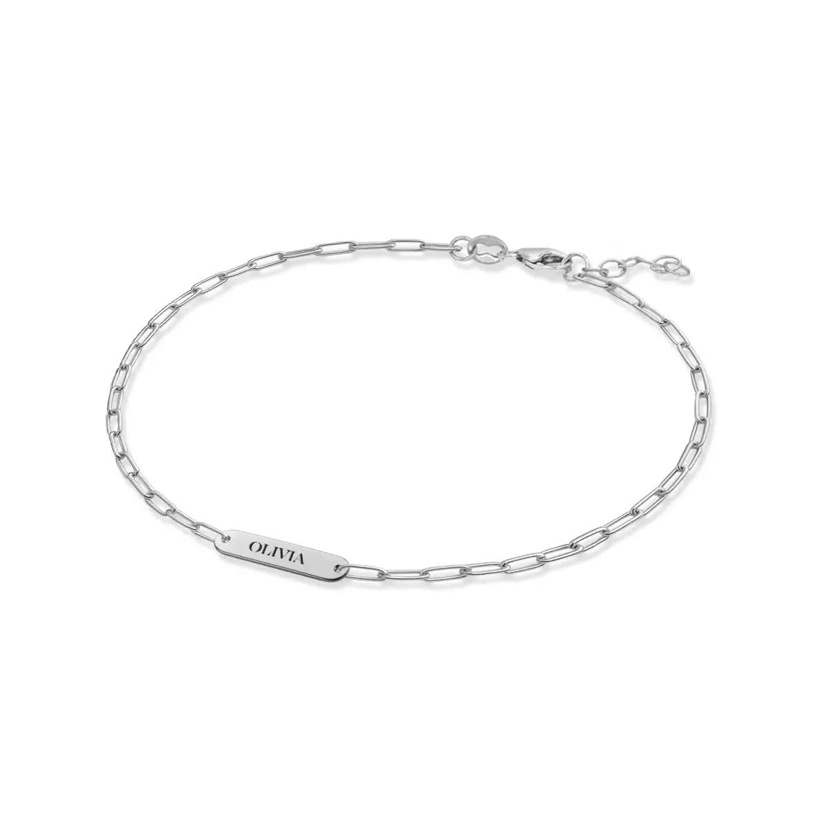 14k White gold engraved nameplate bracelet with "OLIVIA" on slim Adelaide Mini paperclip chain, shown at an angle.