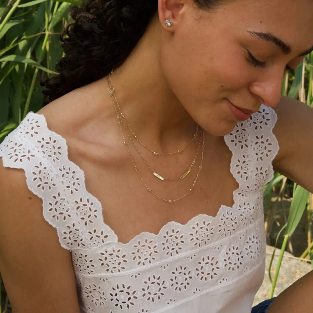 Woman wearing 2 Petite Nameplate Necklace on Adelaide Mini chain in 14k gold, engraved with her children
