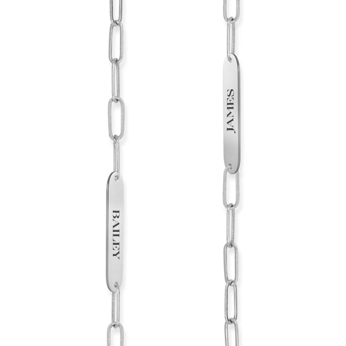 Detail of two 14k white gold flat nameplates engraved with the names Lily and Tyler, shown on Adelaide Mini chain links.