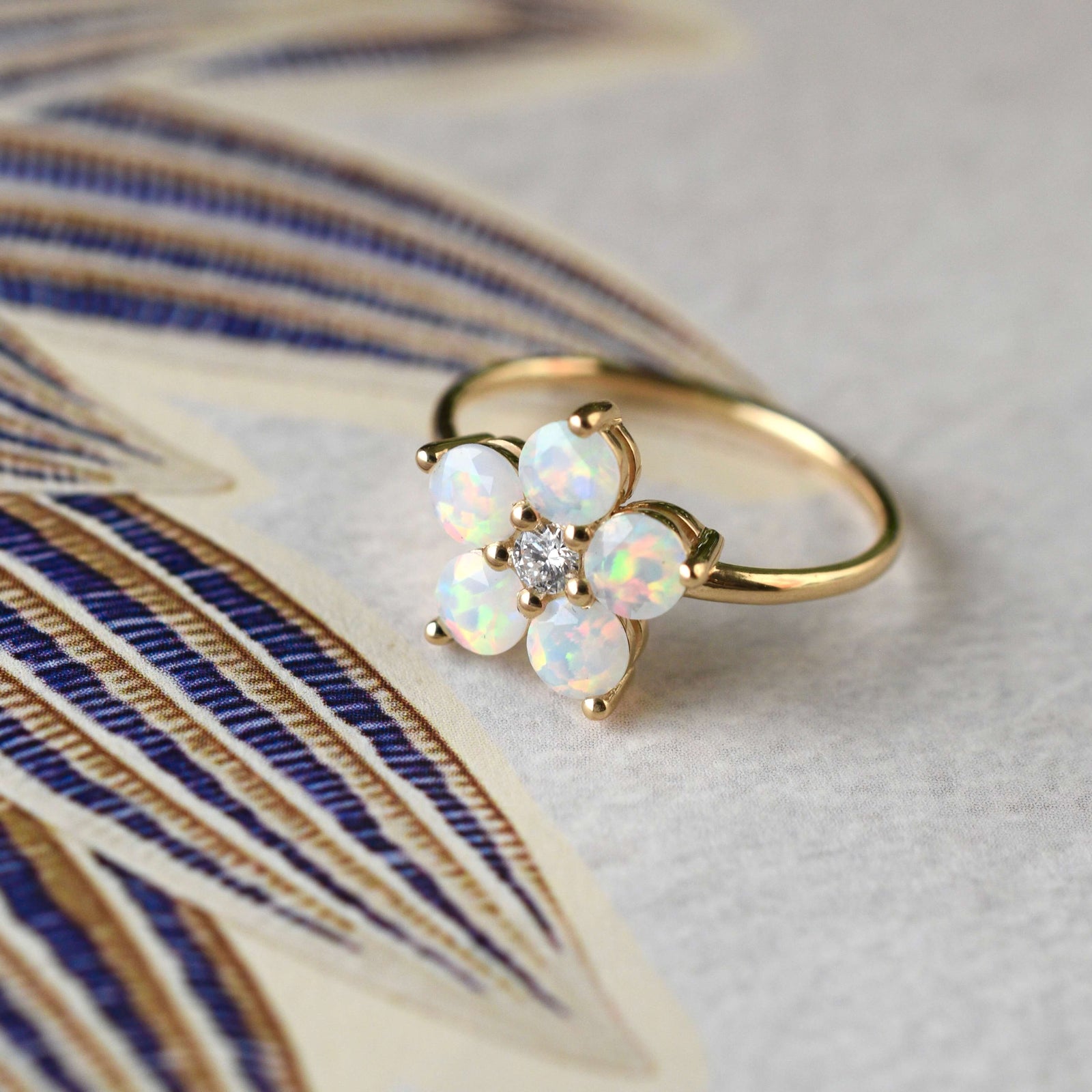 Assorted jewelry including a Greenwich ring featuring five 4 mm faceted round cut opals and one 2.1 mm diamond prong set in 14k gold