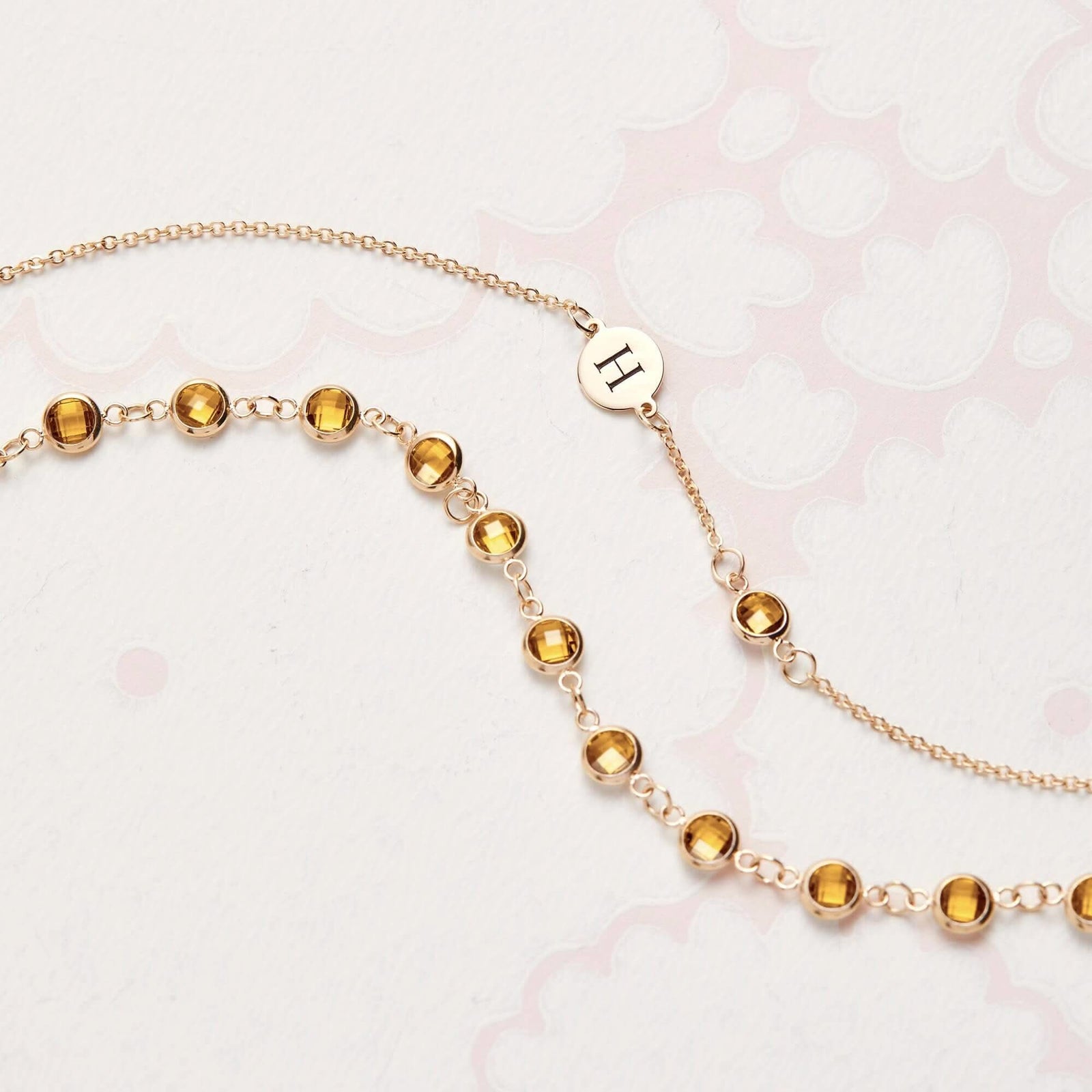 Flatlay of classic Newport Citrine Chain showing round bezel-set gemstones in yellow gold, styled for a November birthstone theme.