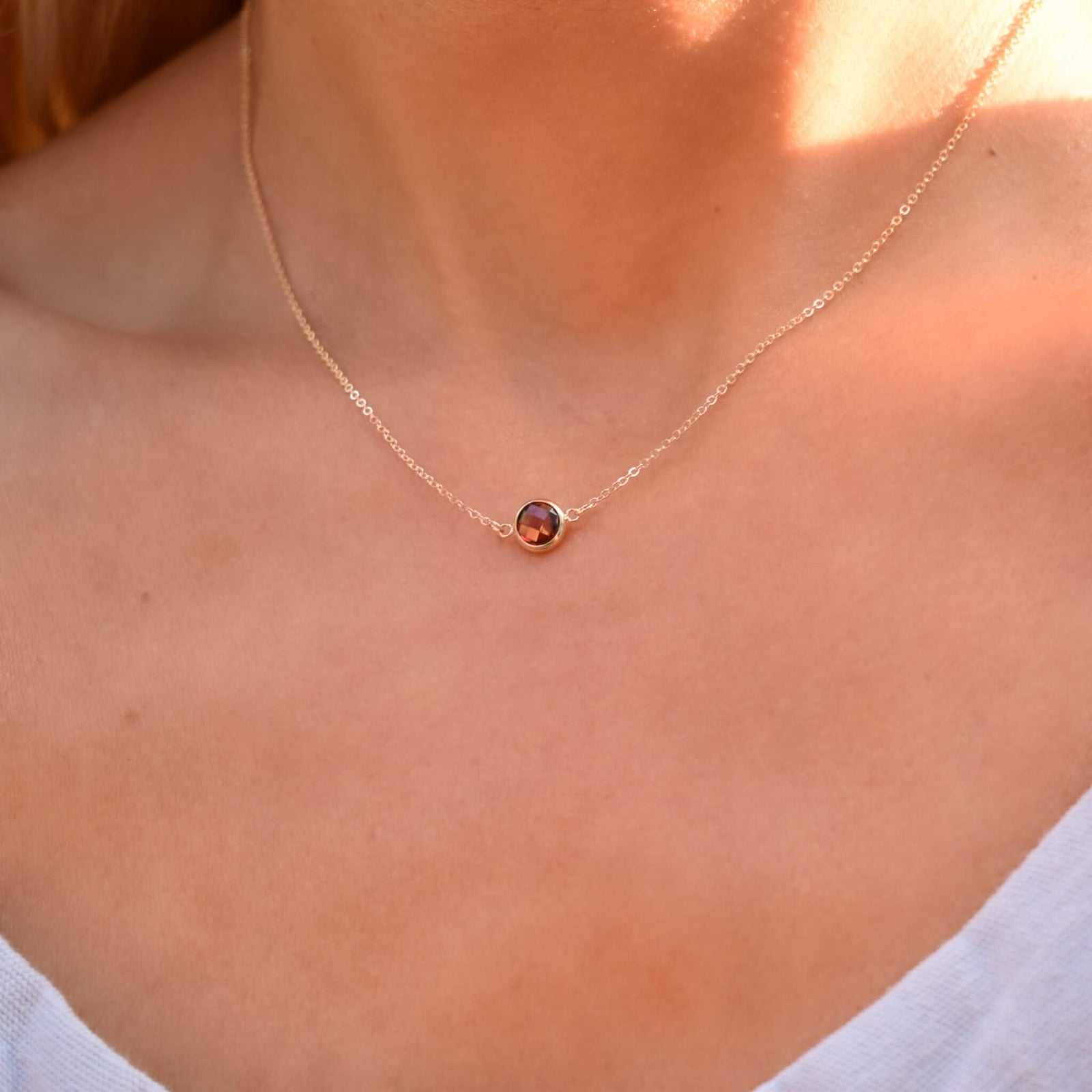 Woman with a Grand 14k yellow gold 1.17 mm cable chain necklace featuring one 6 mm briolette cut bezel set garnet