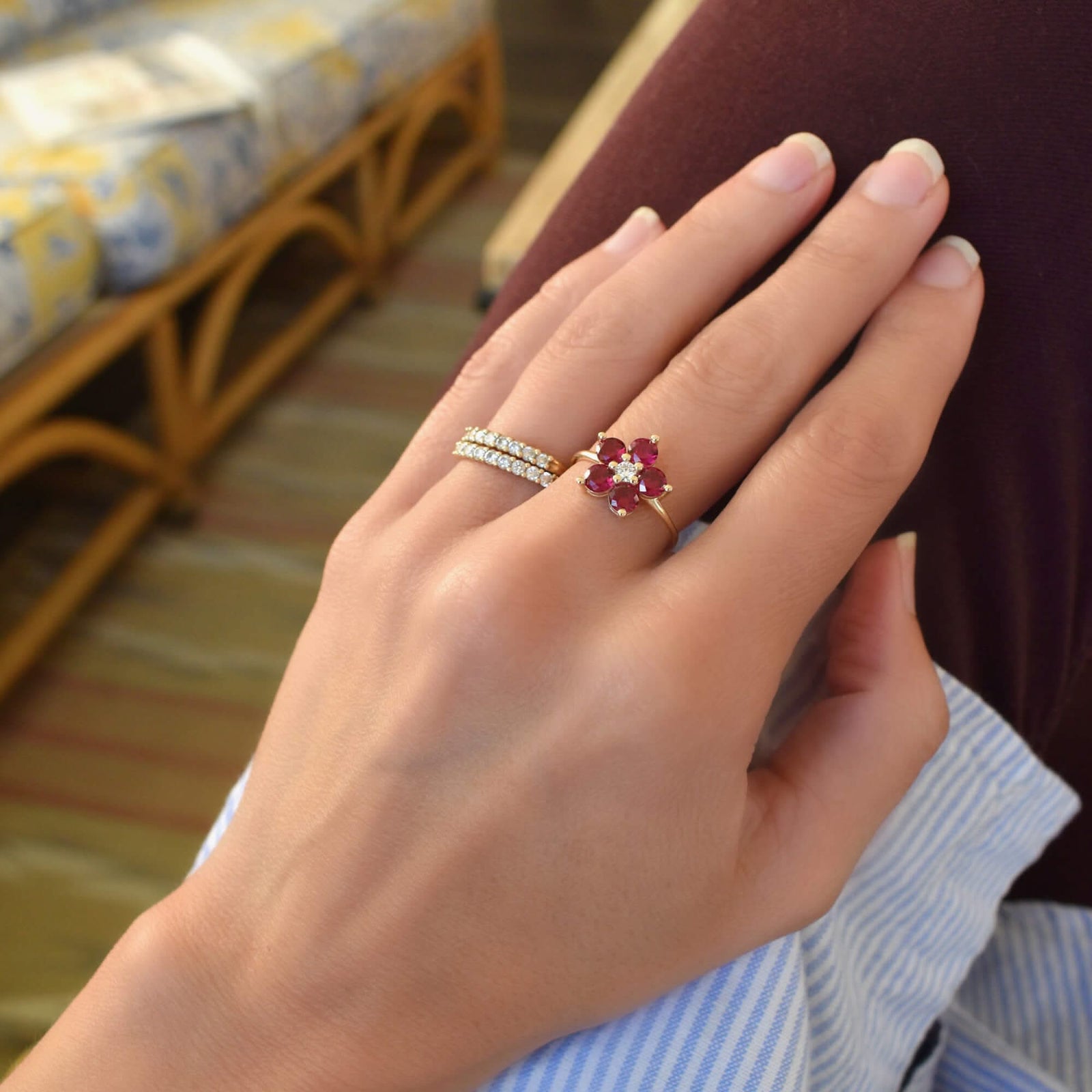 Woman wearing a Greenwich ring featuring five 4 mm faceted round cut white Ruby and one 2.1 mm diamond prong set in 14k gold