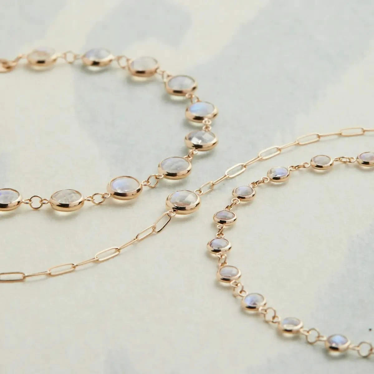 Flatlay of Newport Moonstone Bracelets in 14k Gold with Grand Moonstone and Adelaide Mini Paperclip styles layered together.