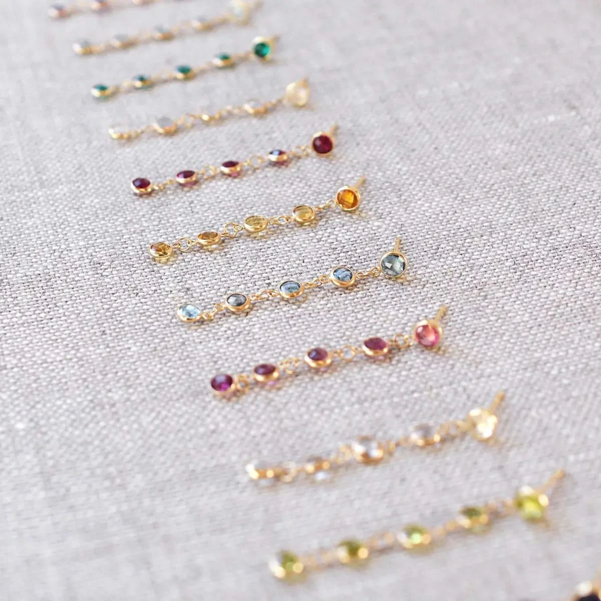 A full set of Newport Earrings in 14k gold, each featuring five bezel-set birthstones representing all 12 months in vibrant colors.
