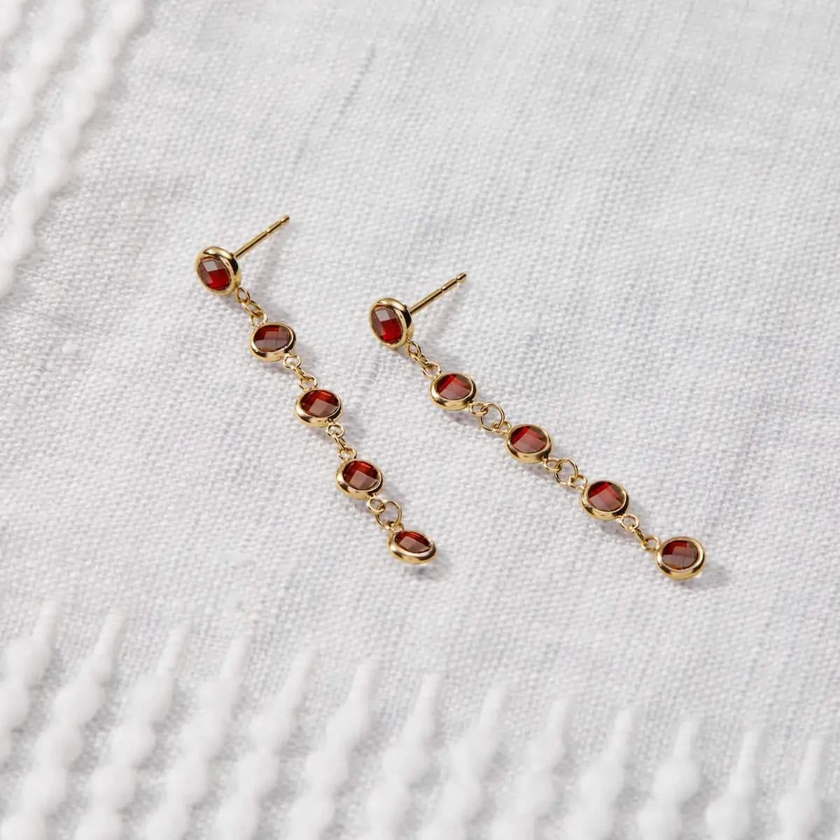 Newport Garnet Earrings in 14k gold were worn to showcase five bezel-set garnets designed for January birthdays.