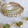 Two Rosecliff Peridot Stackable rings, both featuring eleven faceted round cut gemstones, one with alternating diamonds.