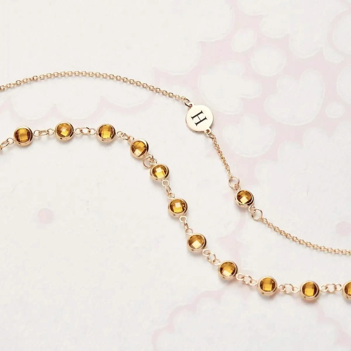 Flatlay of classic Newport Citrine Chain showing round bezel-set gemstones in yellow gold, styled for a November birthstone theme.