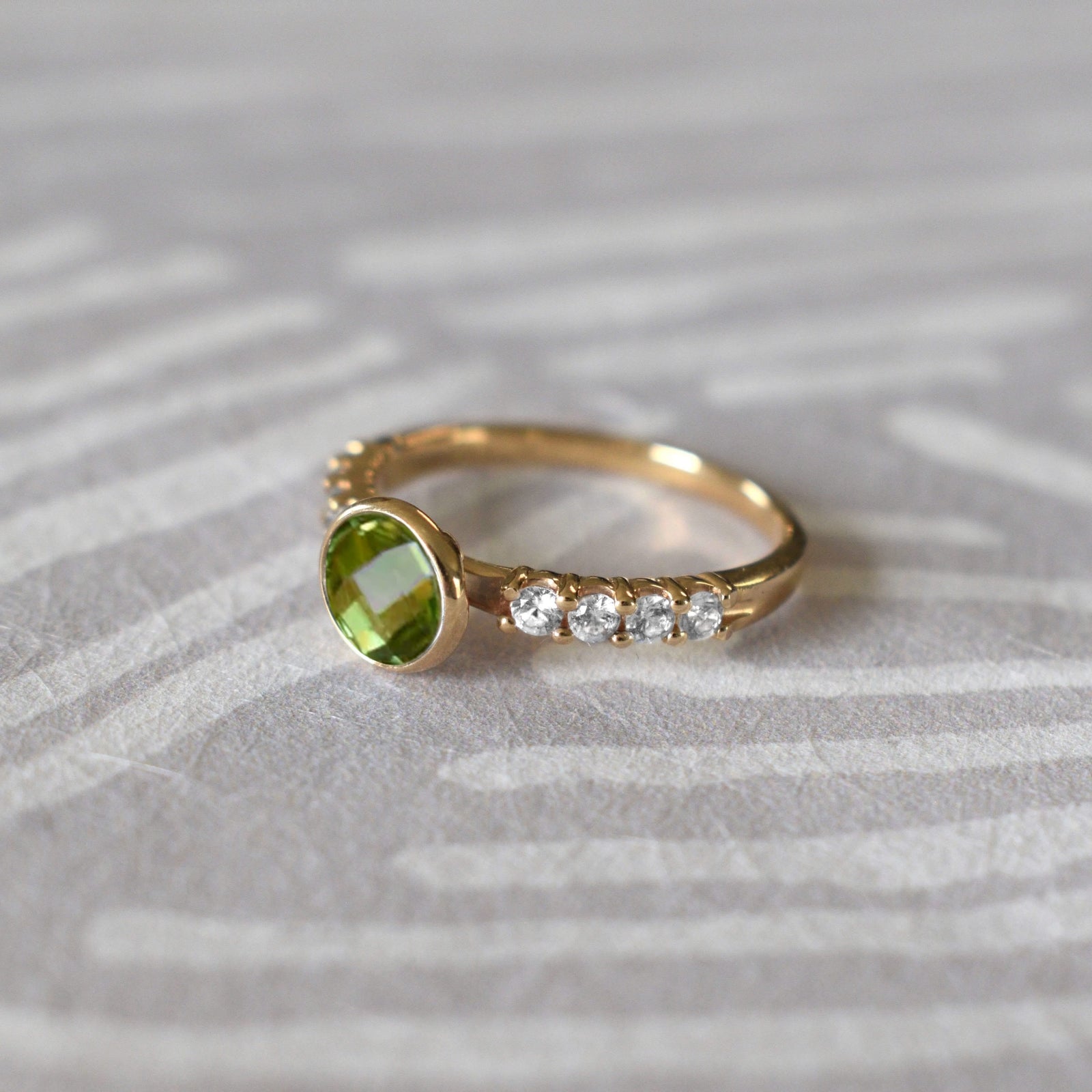 Rosecliff Grand Ring in a 14k gold, featuring a 6 mm round, briolette-cut Peridot and eight 2 mm round-cut Diamonds.