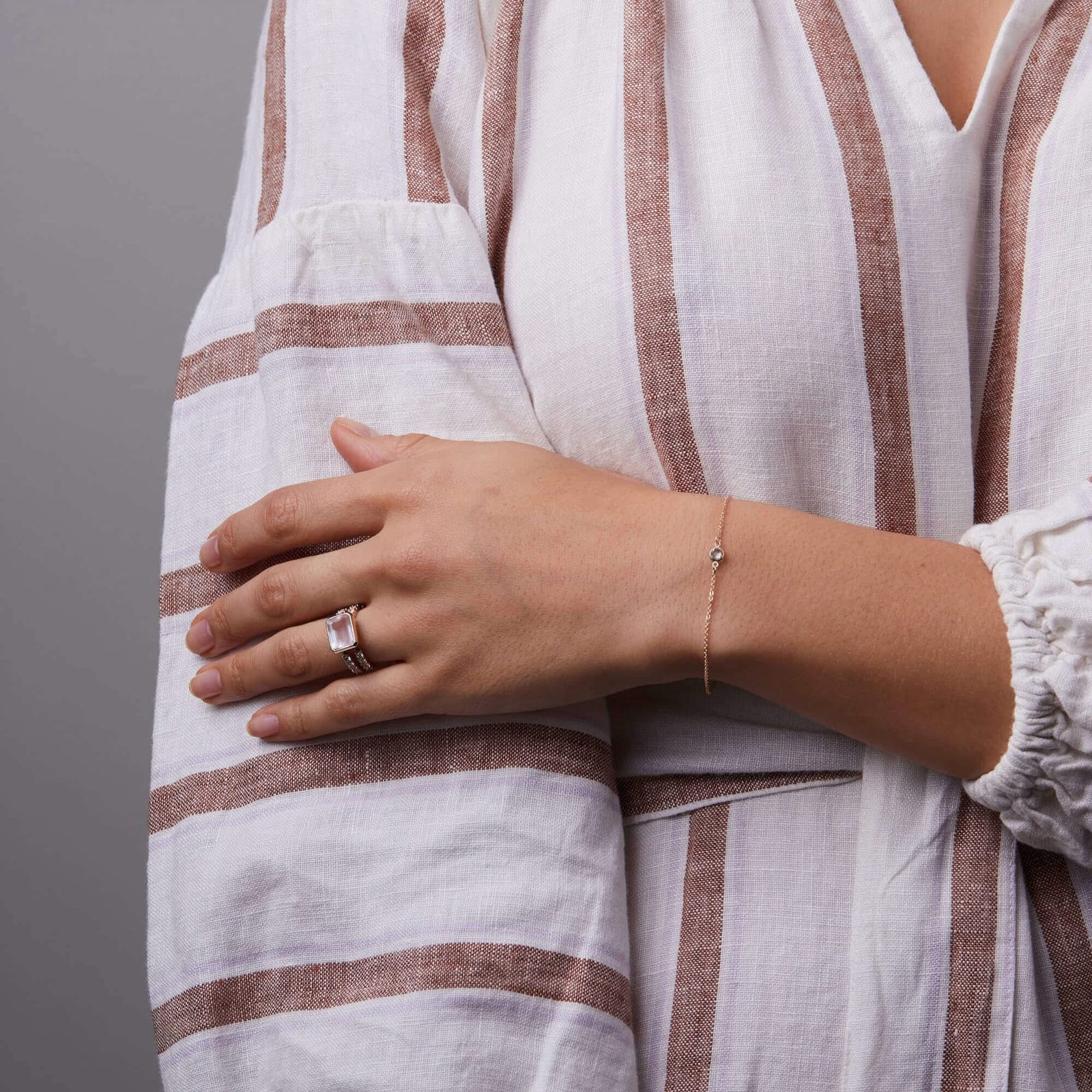 Woman showcasing a 14k yellow gold Warren Horizontal Rose Quartz Ring with Diamonds, showcasing an 8 x 10mm Rose Quartz and 16 prong-set diamonds.