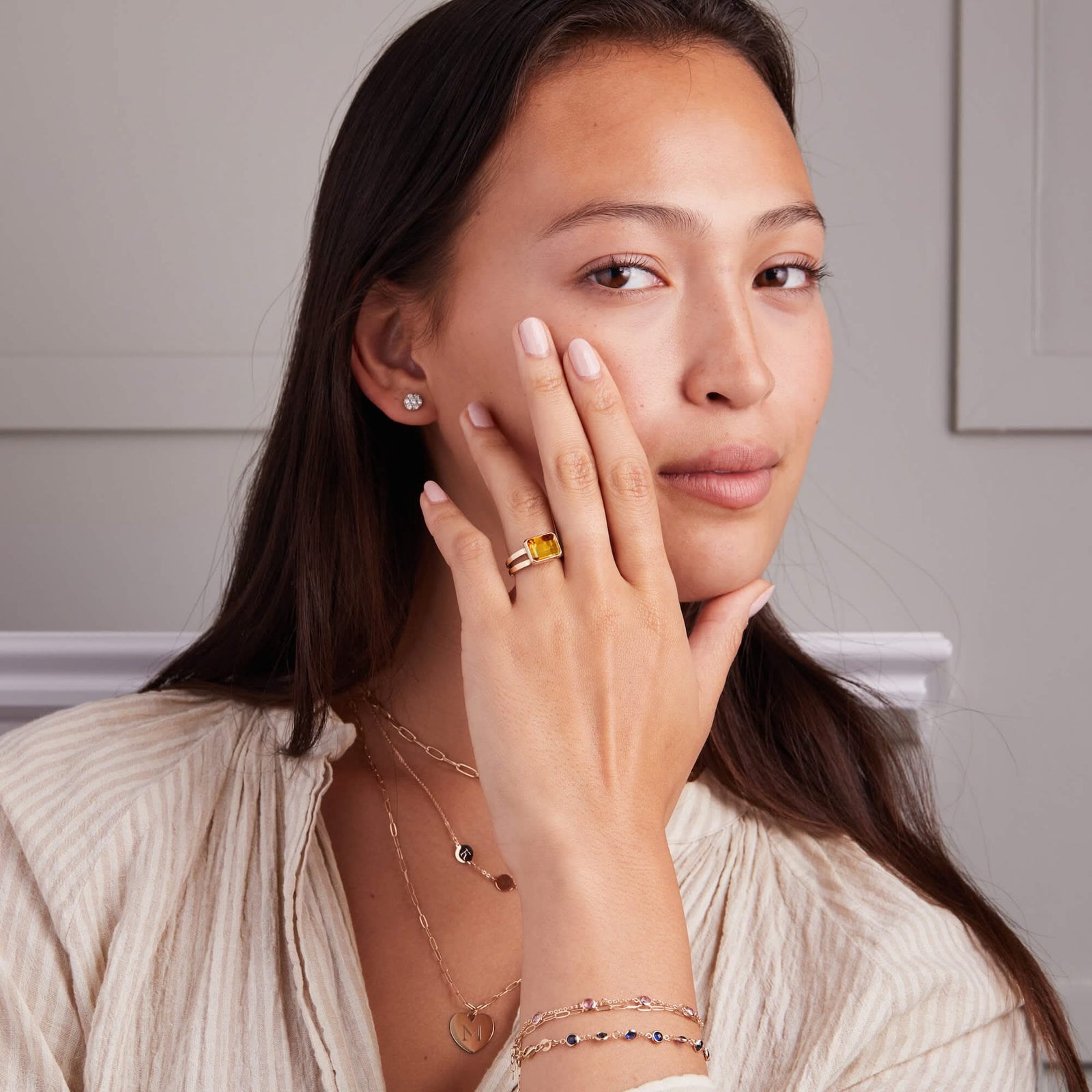 Woman adorned with a 14k yellow gold Warren Horizontal Citrine Ring, showcasing an Citrine-cut 8 x 10mm Nantucket Blue Topaz, hand-set horizontally in a 14k-gold bezel.
