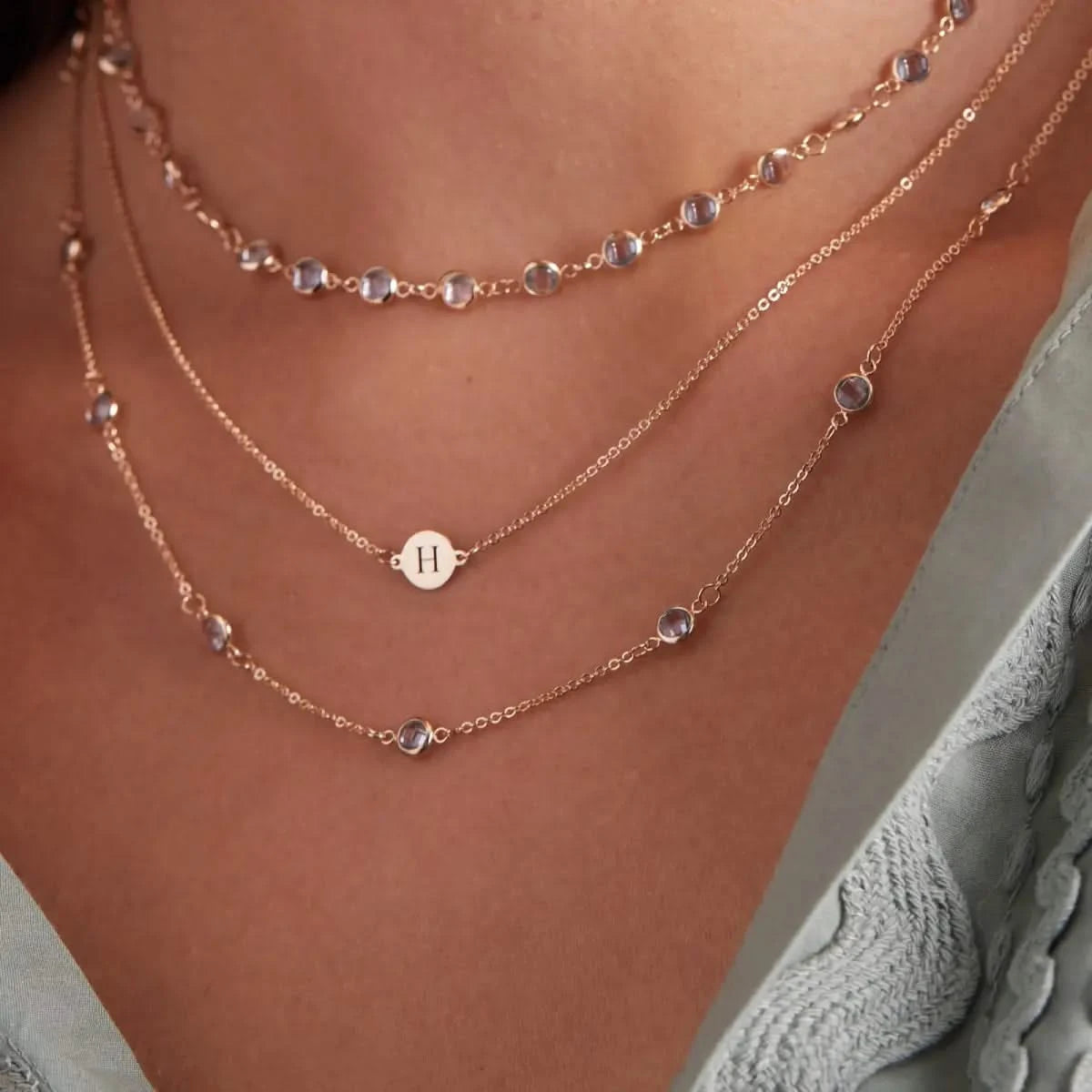 Newport Aquamarine necklace layered with engraved initial necklace in 14k gold.