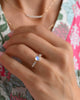 Woman's hand wearing a Rosecliff Grand Moonstone ring featuring a 6mm briolette cut center stone and eight 2mm accent stones.