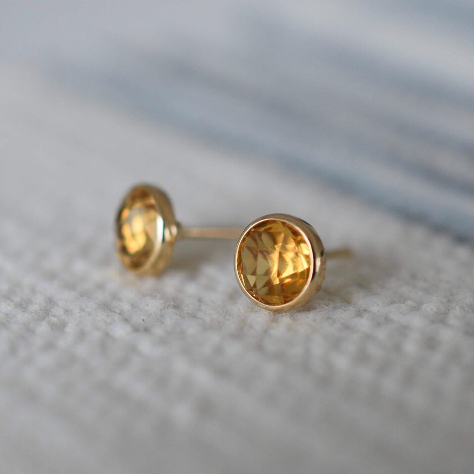 A pair of Stud earring featuring 6 mm briolette cut bezel set Citrine in a 14k yellow gold.