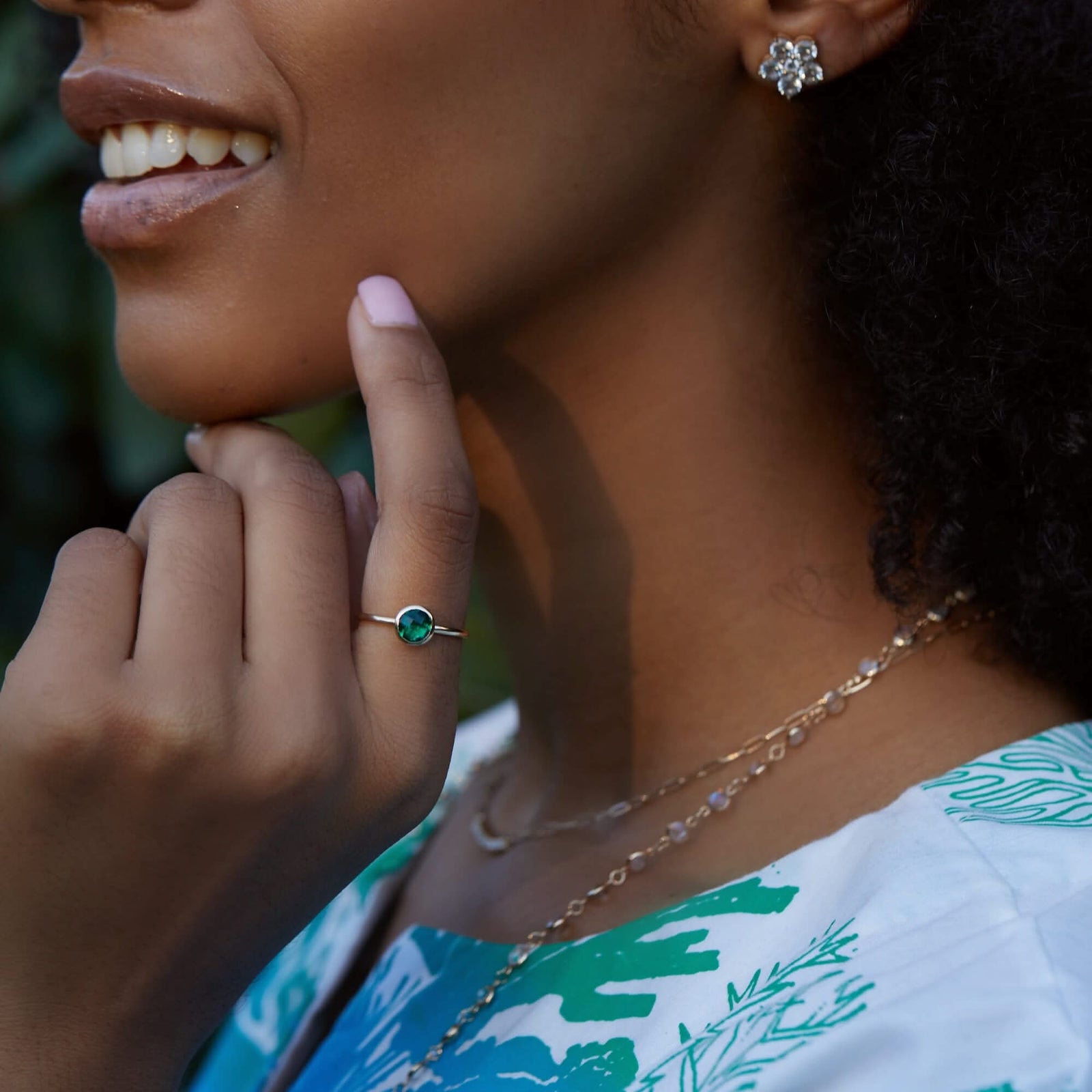 Woman with a personalized Grand Birthstone Rings with a 6mm round briolette-cut Emerald gemstone.