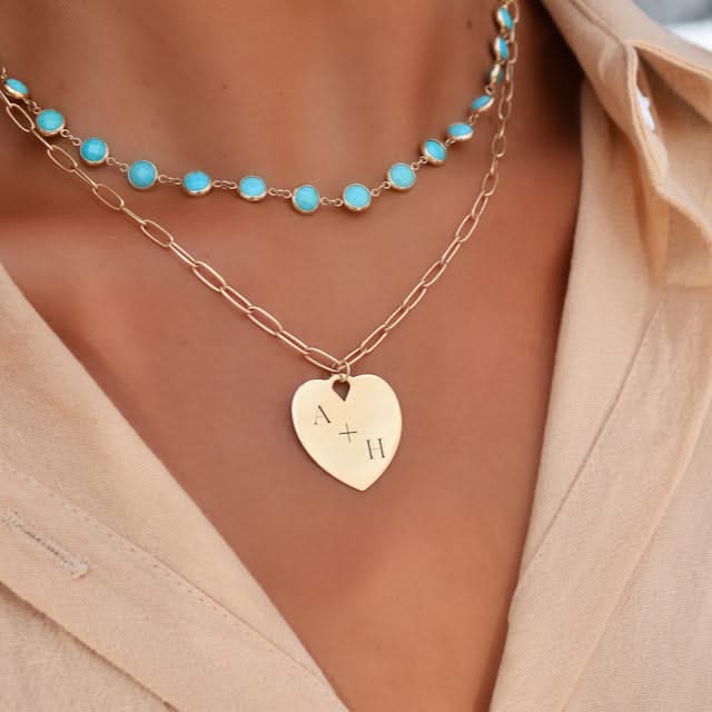 Layered necklace look featuring a 14k gold heart pendant engraved with “A + H” on an Adelaide chain, styled below Newport Grand Turquoise gemstone necklace for a personalized and colorful pairing.