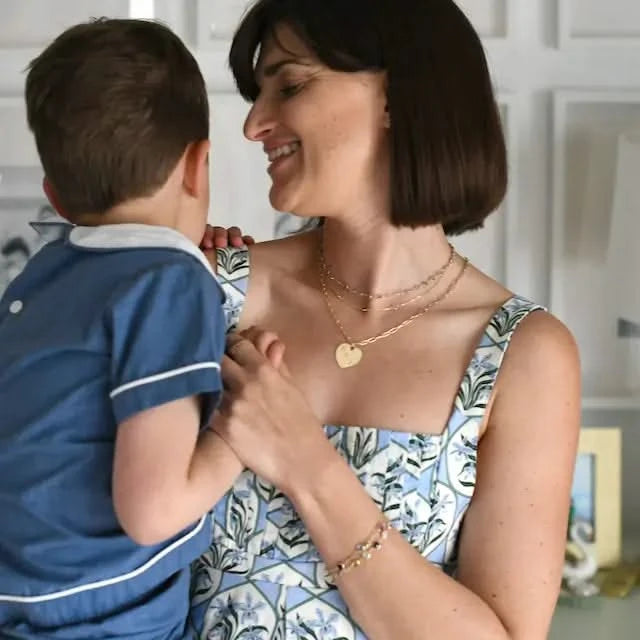 Mother wearing a layered necklace featuring the Large Flat Heart Pendant engraved with kid