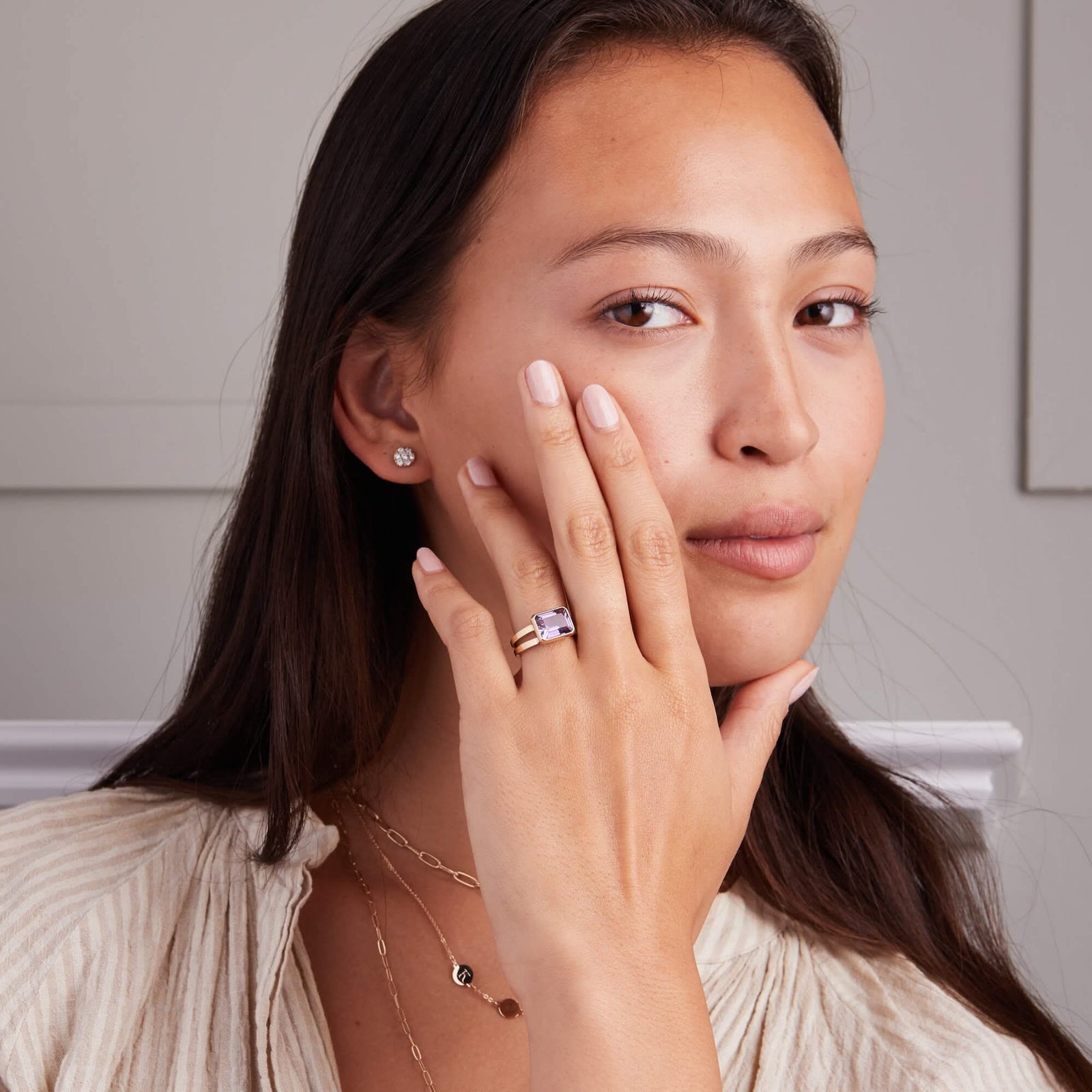 Woman wearing Personalized Warren Horizontal Birthstone Ring with emerald-cut birthstone, hand-set horizontally in a 14k-gold bezel.