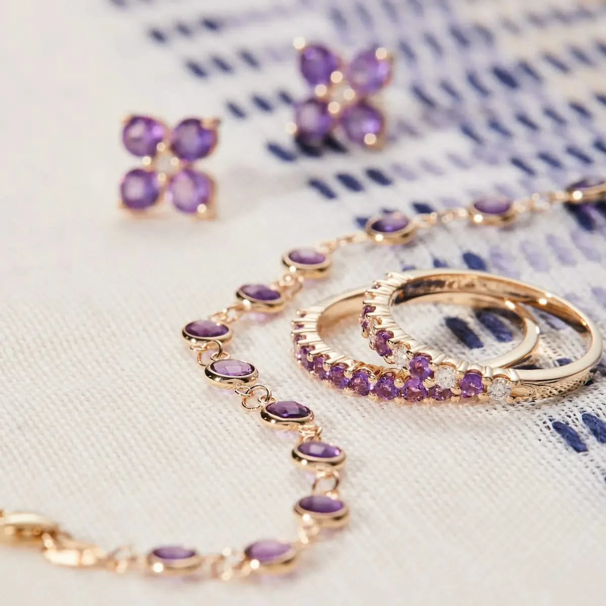 Newport Amethyst Bracelet styled with matching Amethyst stud earrings and stacking rings, all set in 14k gold.