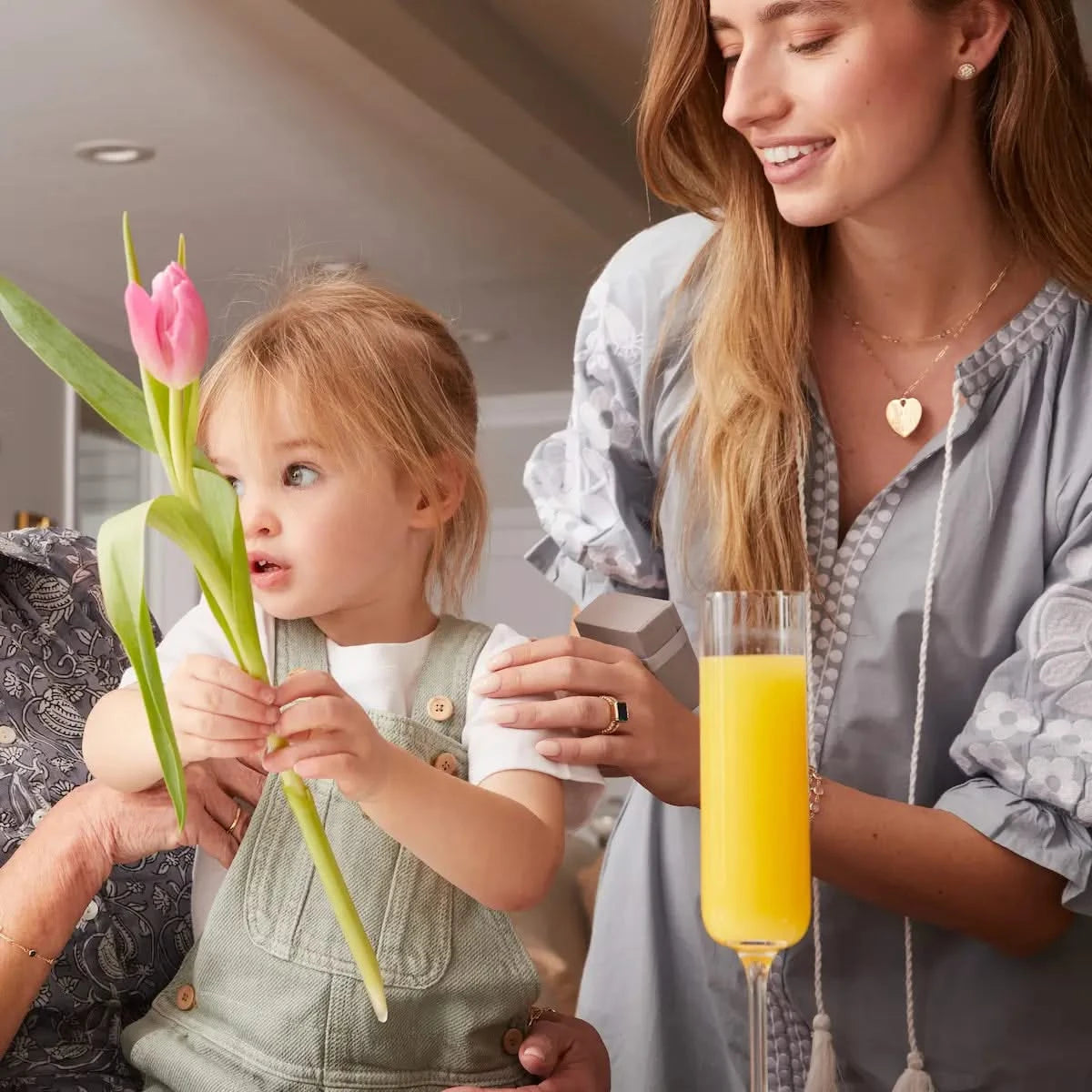 Woman wearing Heart pendant necklace in 14k gold during joyful family moment.