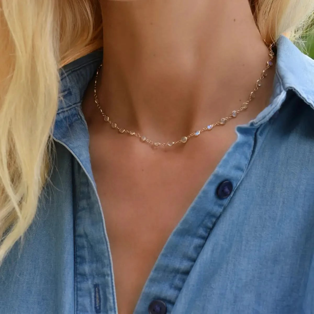 Woman wearing a Newport necklace featuring 4 mm briolette cut moonstones bezel set in 14k yellow gold