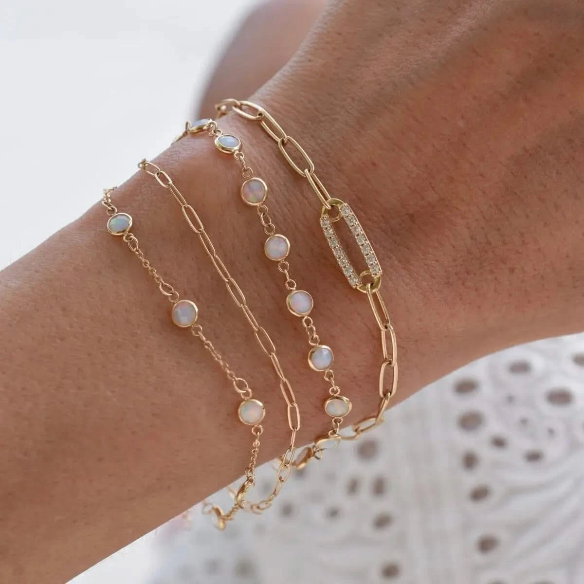 Stacked Newport Opal Bracelets paired with a gold chain bracelet on wrist.