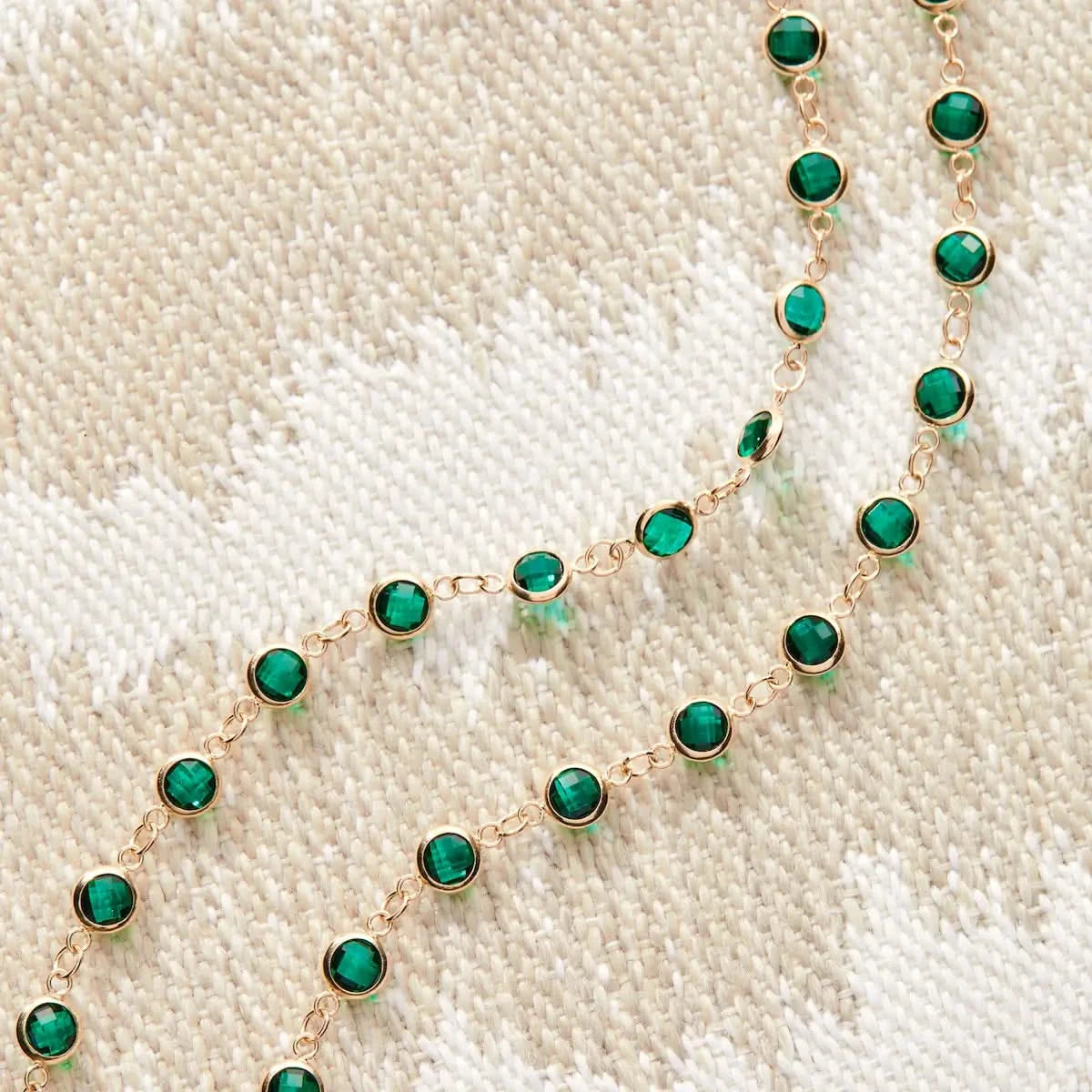 Close-up of the Newport Emerald Necklace with round bezel-set emeralds in 14k gold.