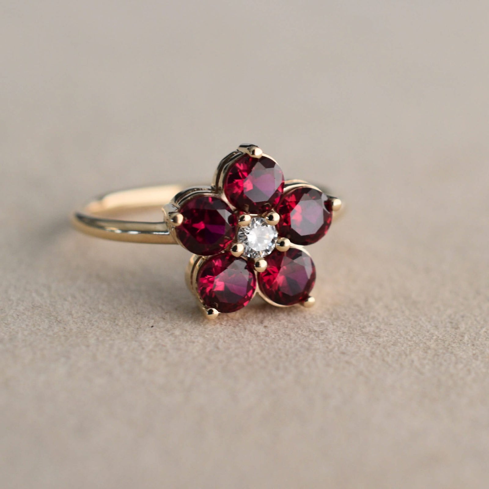 Greenwich ring featuring four 4 mm faceted round cut Ruby and one 2.1 mm diamond prong set in 14k gold