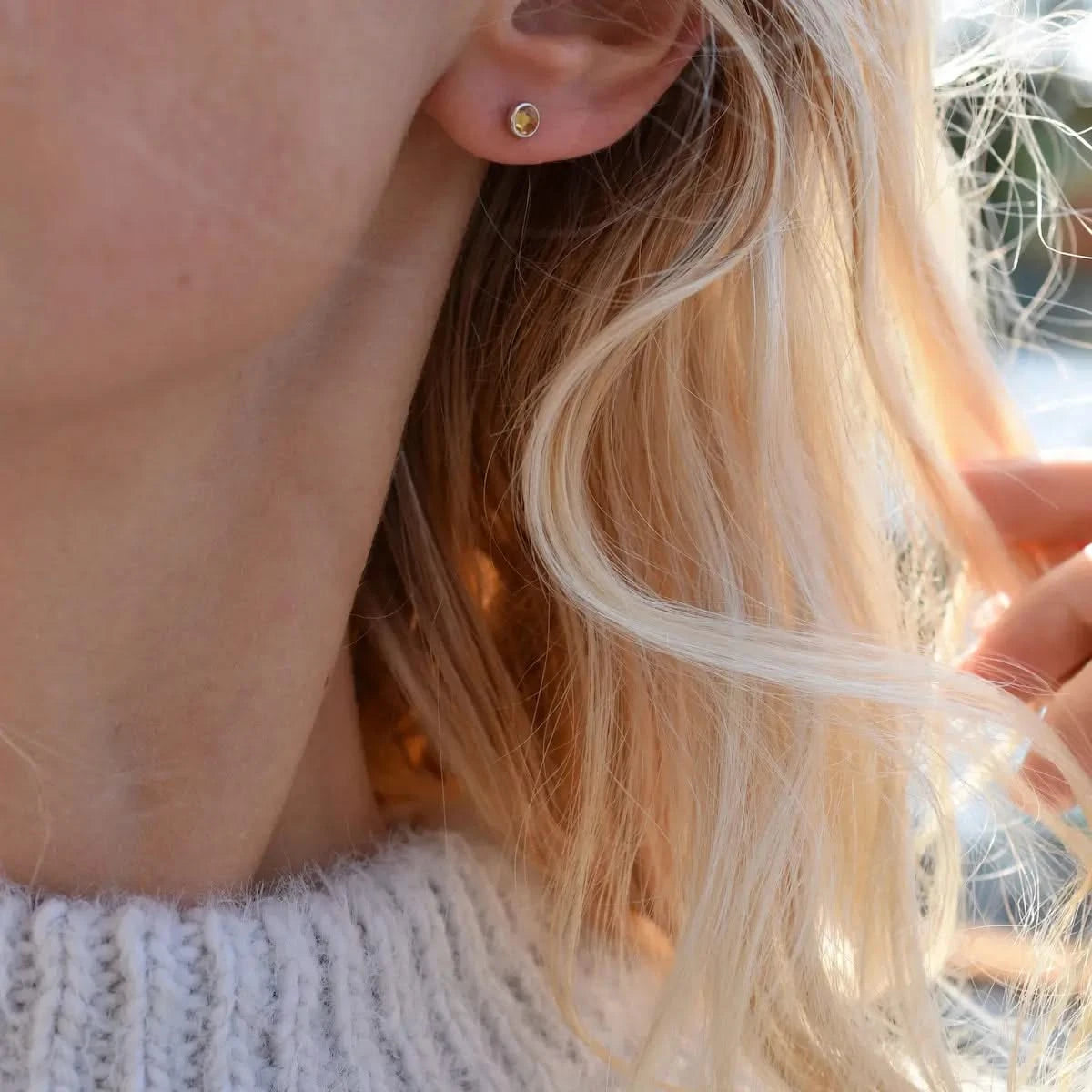 Woman wearing a Birthstone Stud Earring featuring a 4 mm briolette cut Citrine bezel set in 14k white gold