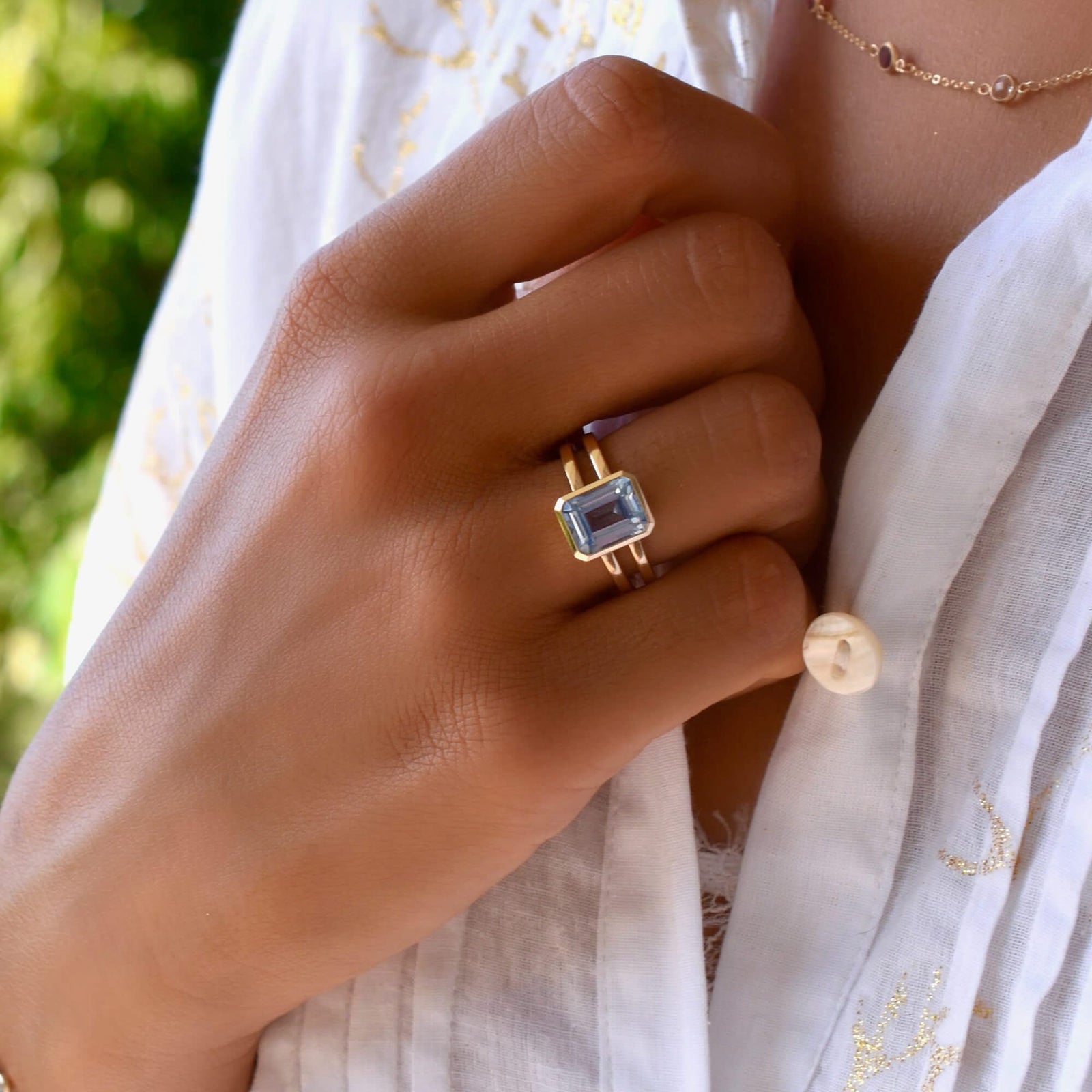 The Warren ring, crafted in 14k yellow gold, features a vertically placed, bezel-set emerald-cut Aquamarine measuring 10 x 8 mm.