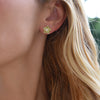 Woman wearing a 14k yellow gold Greenwich 5 Birthstone earring featuring five 4 mm peridots and one 2.1 mm diamond