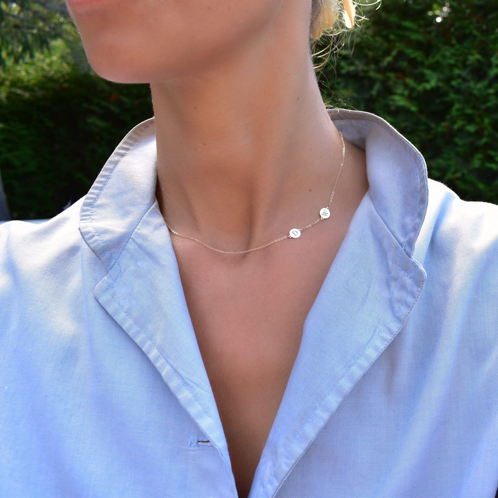 Woman wearing a 14k yellow gold cable chain necklace featuring two 1/4” flat discs engraved with the letters D and W