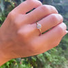 Woman's hand wearing a 1.6 mm wide 14k yellow gold Grand ring featuring one 6 mm briolette cut bezel set aquamarine