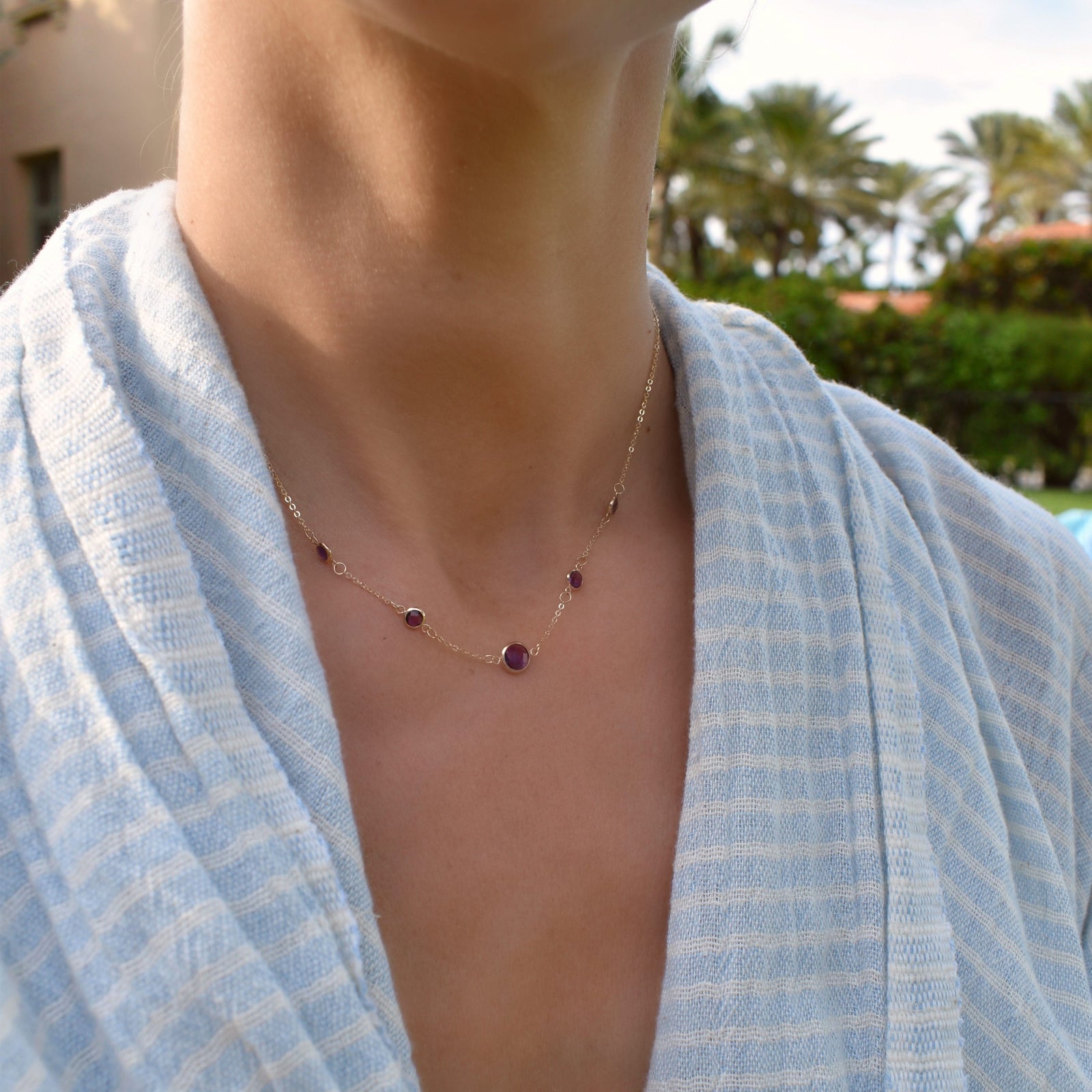 Woman wearing a Grand & Classic necklace featuring one 6 mm and four 4 mm Amethysts bezel set in 14k yellow gold