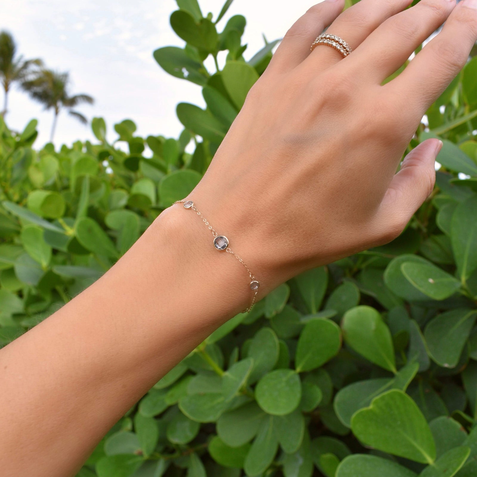 Woman wearing a Grand & Classic bracelet featuring one 6 mm and four 4 mm briolette Aquamarines bezel set in 14k yellow gold