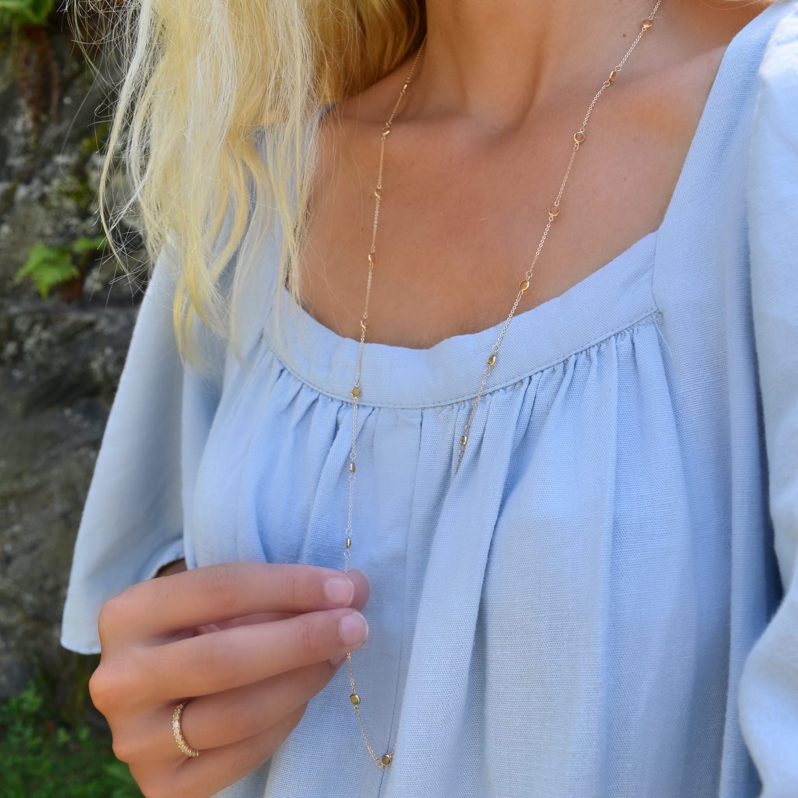 Woman wearing a Bayberry Birthstone Wrap necklace featuring 4 mm briolette cut citrines bezel set in 14k gold