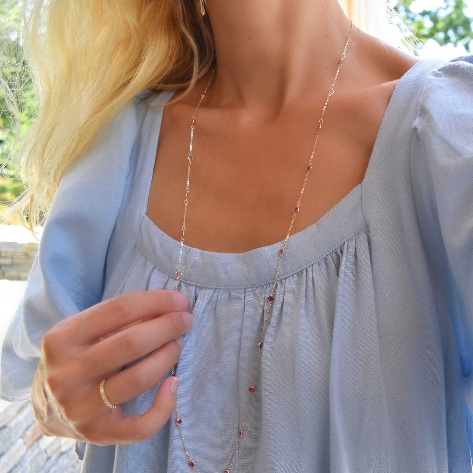 Woman wearing a Bayberry Birthstone Wrap necklace featuring 4 mm briolette cut pink tourmalines bezel set in 14k yellow gold