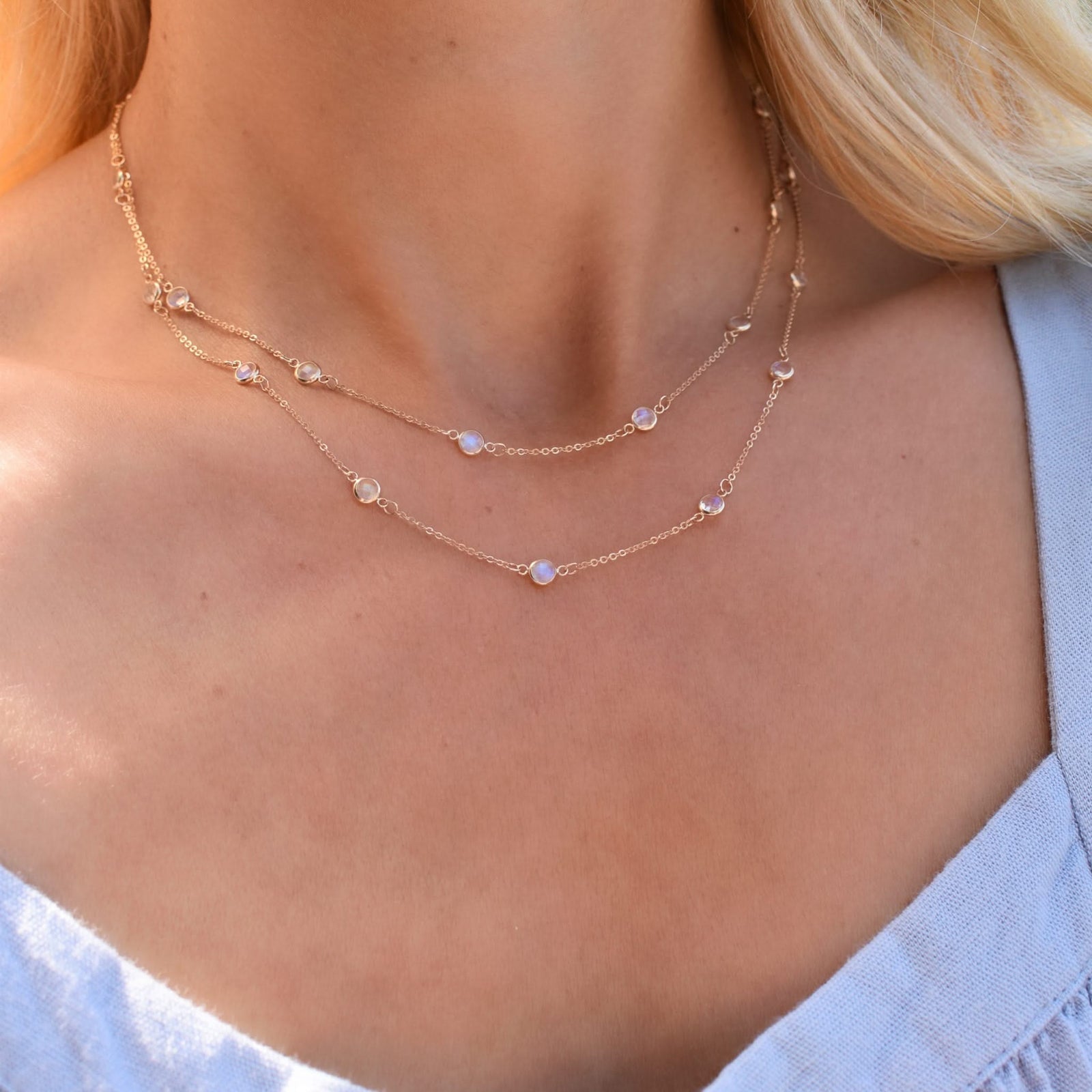 Woman wearing a Bayberry Birthstone Wrap necklace featuring 4 mm briolette cut moonstones bezel set in 14k yellow gold