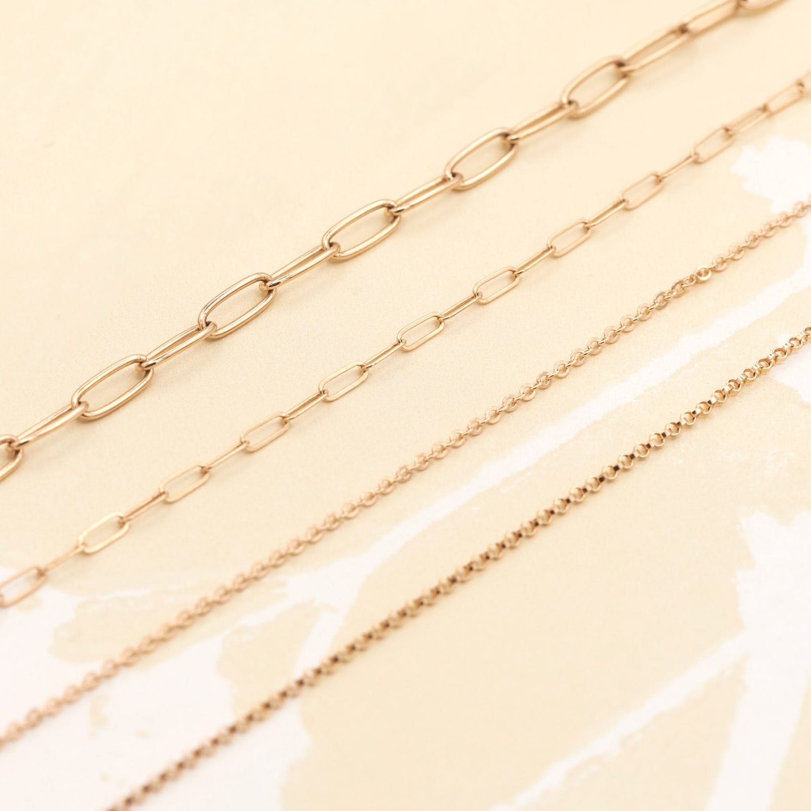 Various necklaces including the Saffron 14k yellow gold rolo chain necklace