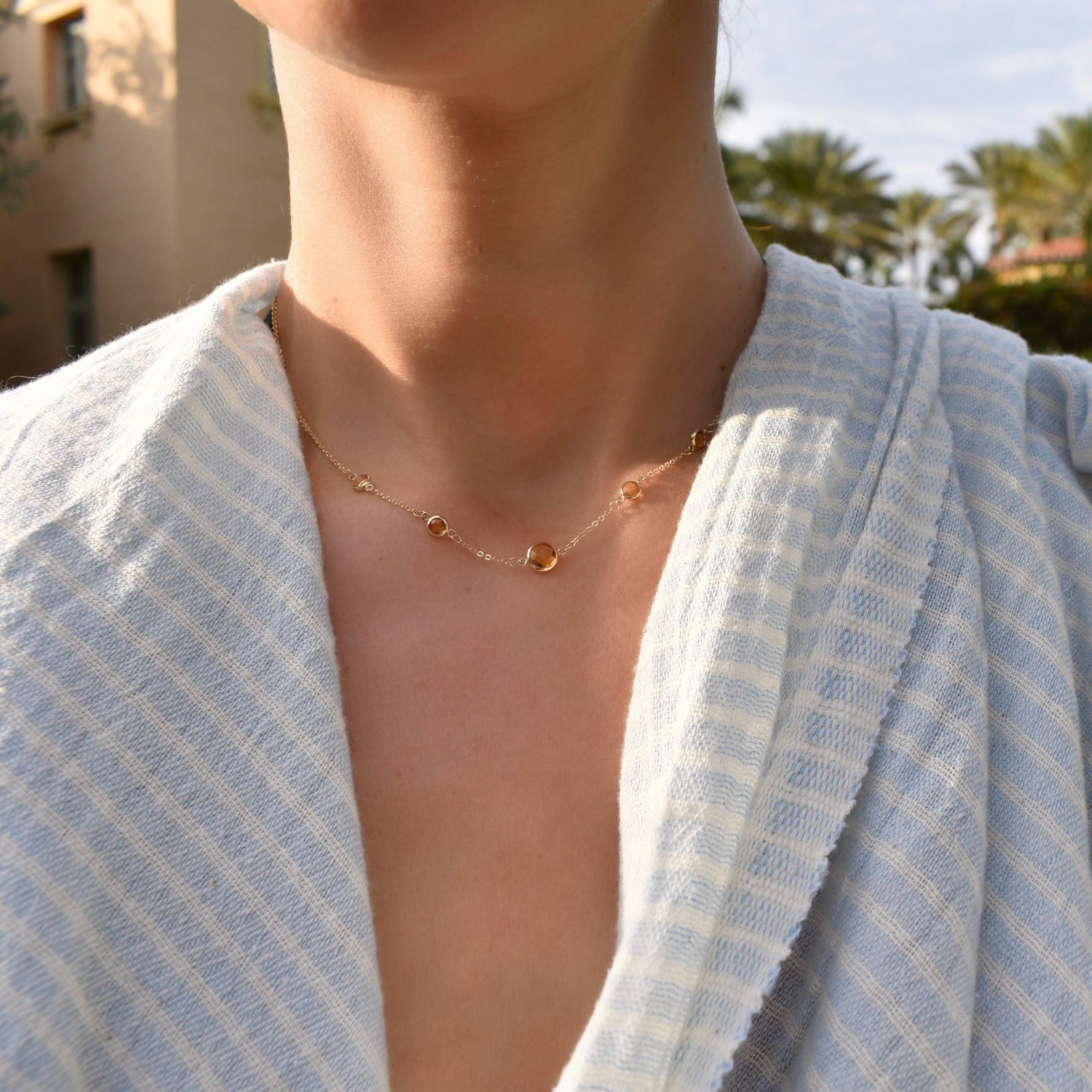 Woman wearing a Grand & Classic necklace featuring one 6 mm and four 4 mm Citrines bezel set in 14k yellow gold