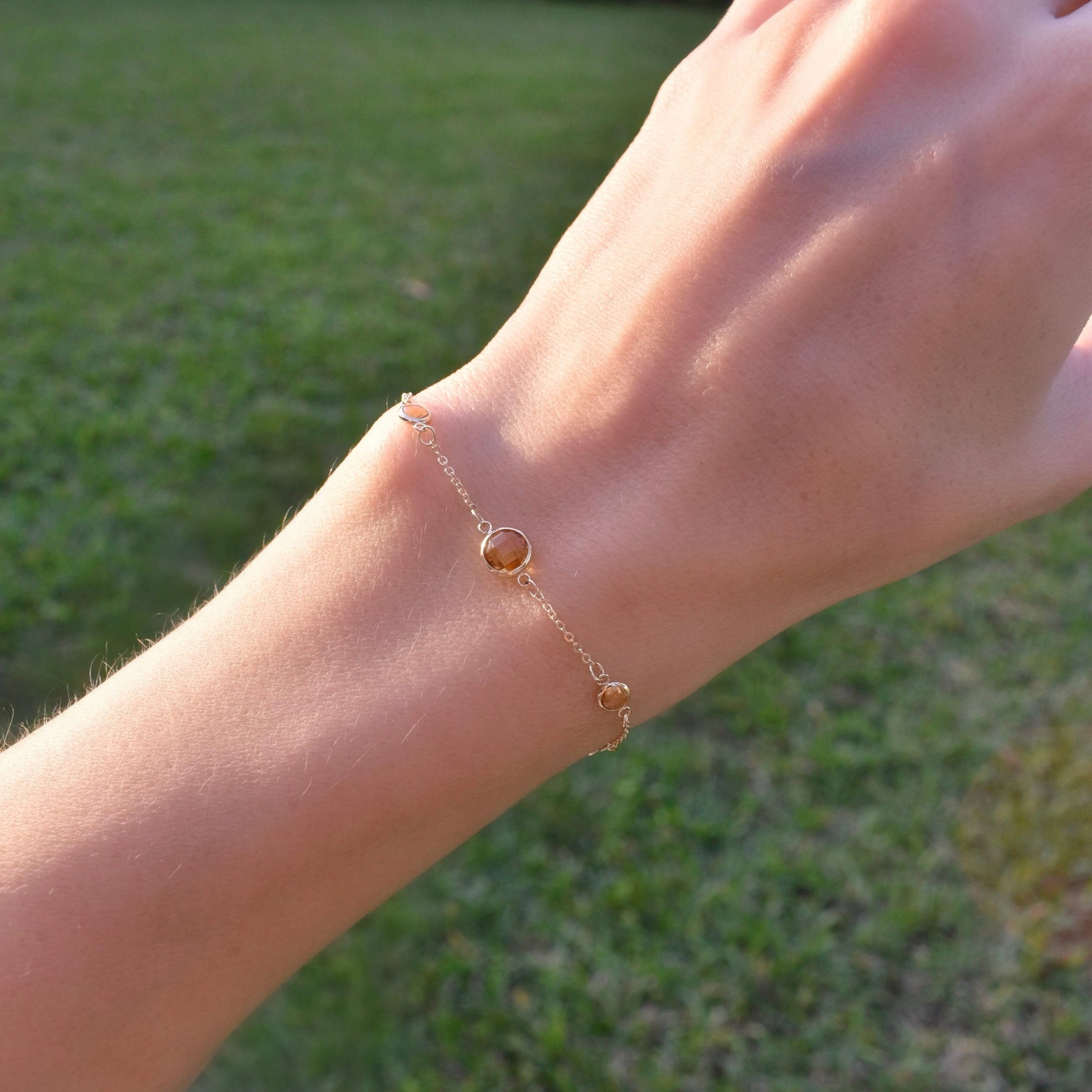 Woman wearing a Grand & Classic bracelet featuring one 6 mm and four 4 mm briolette Citrines bezel set in 14k yellow gold
