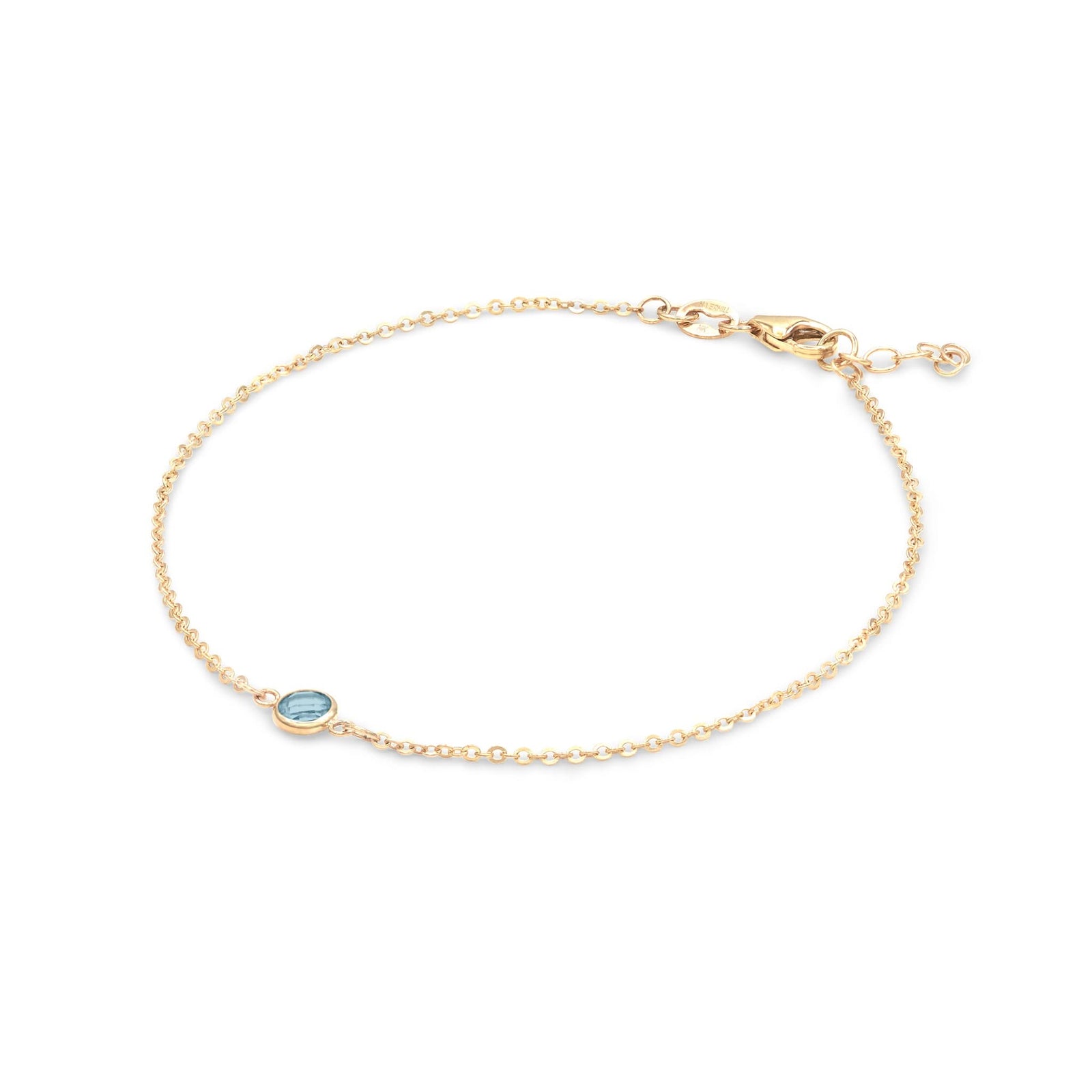 Classic cable chain bracelet featuring one 4 mm briolette cut Nantucket blue topaz bezel set in 14k yellow gold - angled view