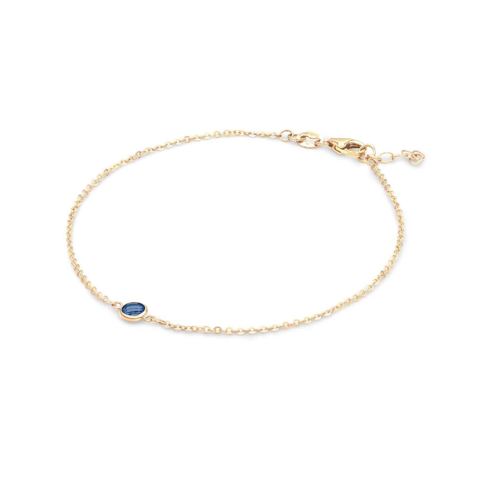 Classic cable chain bracelet featuring one 4 mm briolette cut sapphire bezel set in 14k yellow gold - angled view