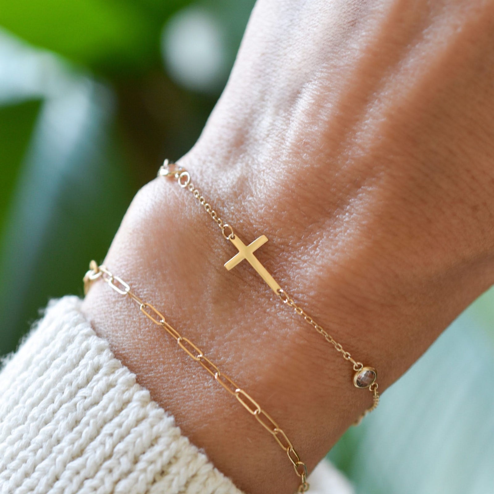 Woman wearing two bracelets including a 14k yellow gold Classic necklace featuring two birthstones and a 1/2" cutout cross