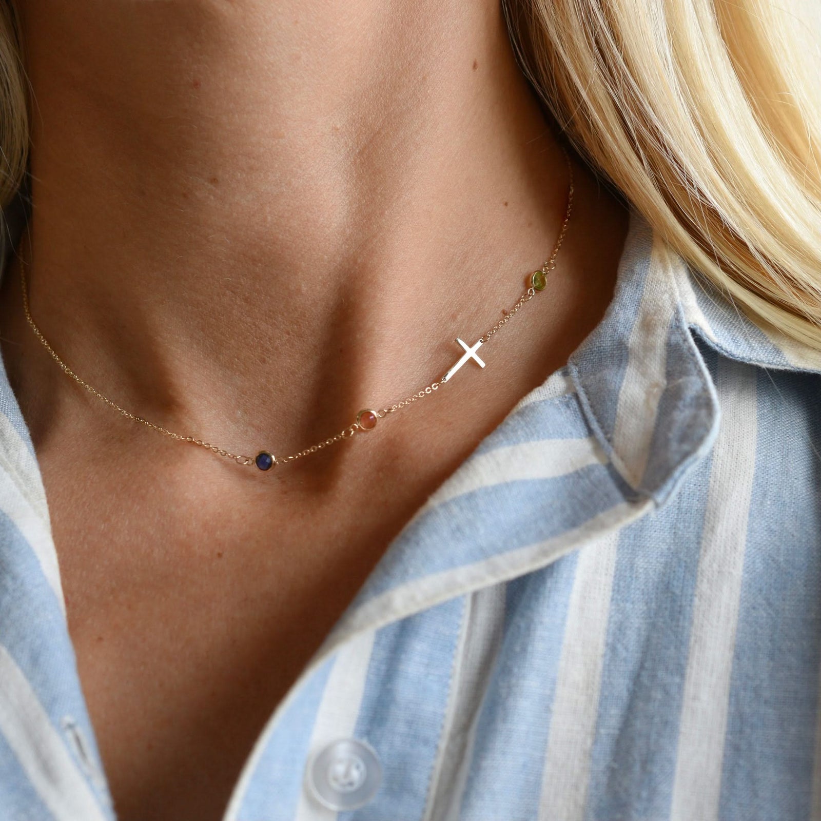 Woman wearing a 14k yellow gold 1.17 mm cable chain necklace featuring three round birthstones and a 1/2" cutout cross