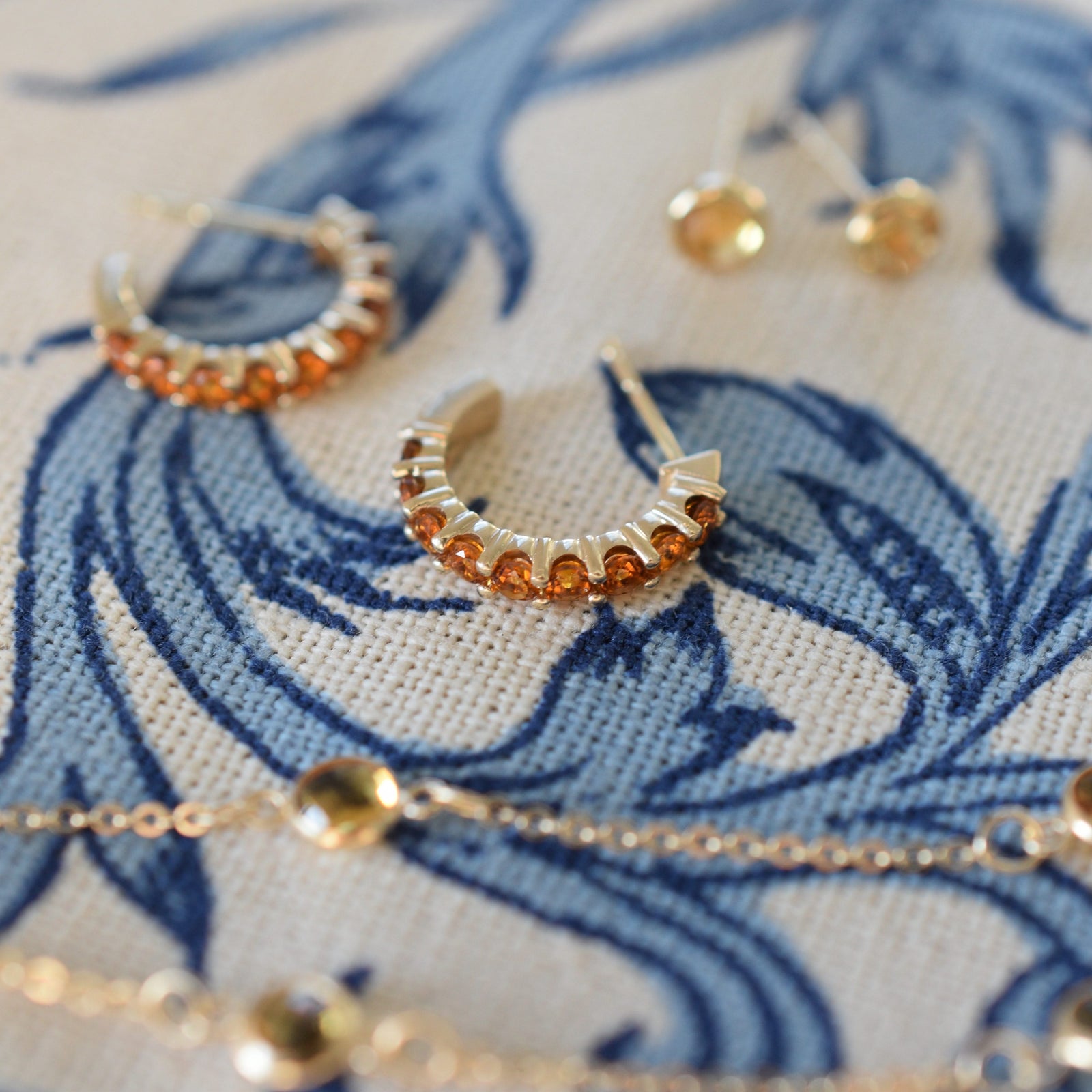 Assorted jewelry including a pair of Rosecliff huggie earrings featuring 2 mm round cut citrines prong set in 14k gold