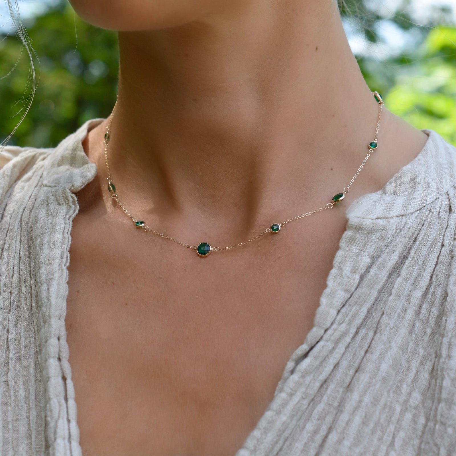 Woman wearing a Bayberry Grand & Classic 14k yellow gold necklace featuring alternating 4 mm and 6 mm briolette cut emeralds