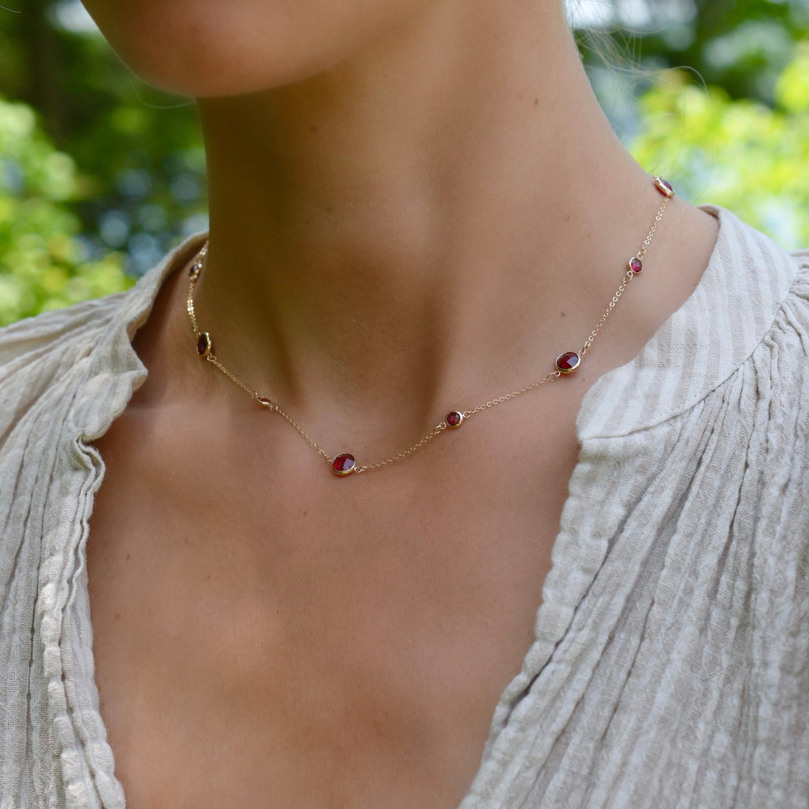 Woman wearing a Bayberry Grand & Classic 14k gold necklace featuring alternating 4 mm and 6 mm briolette cut bezel set rubies