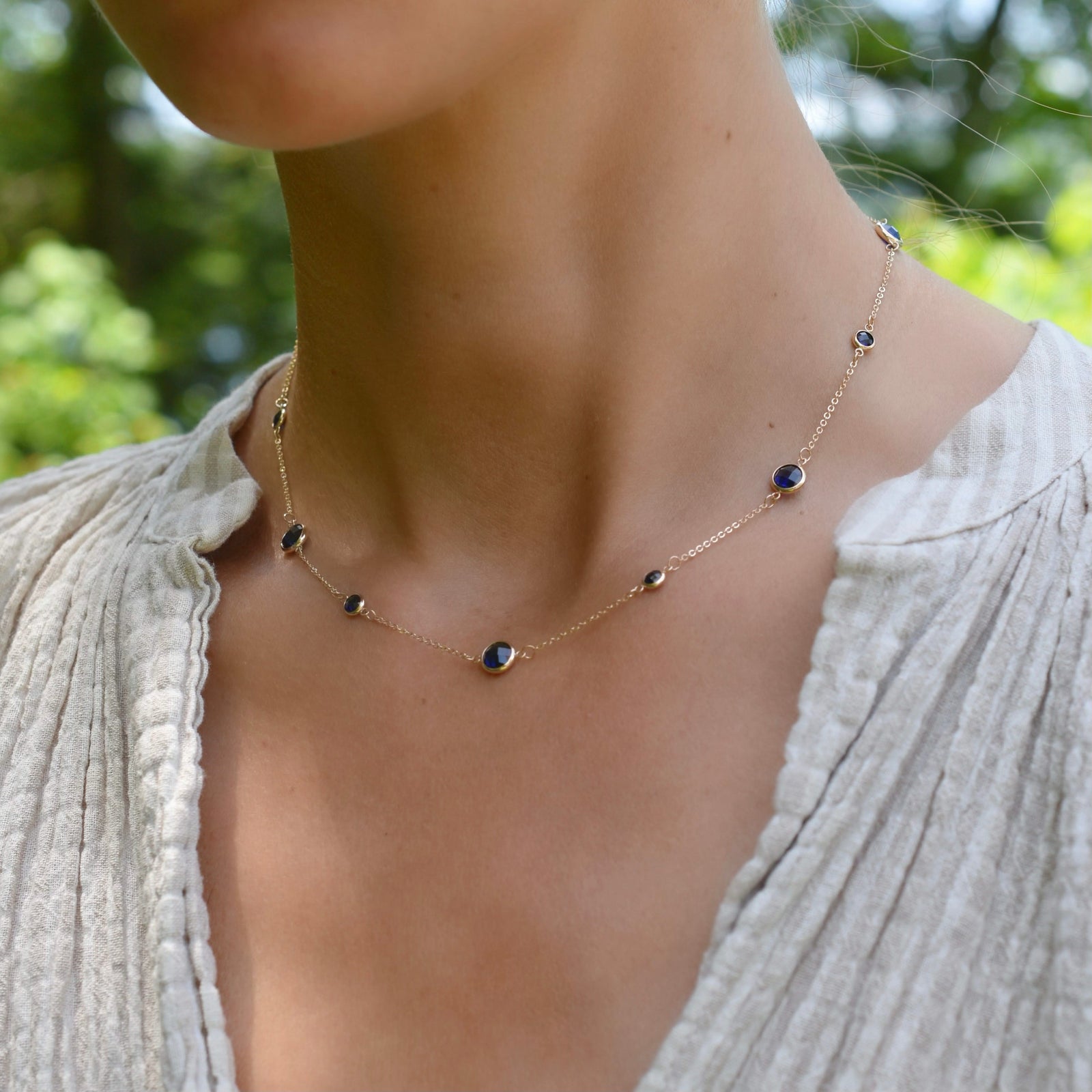 Woman with a Bayberry Grand & Classic 14k gold necklace featuring alternating 4 mm and 6 mm briolette cut sapphires